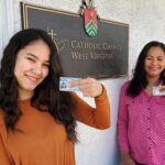 Nancy and Marion display their newly obtained Lawful Permanent Resident cards