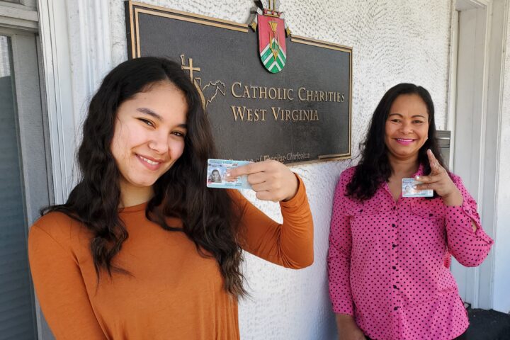 Nancy and Marion display their newly obtained Lawful Permanent Resident cards