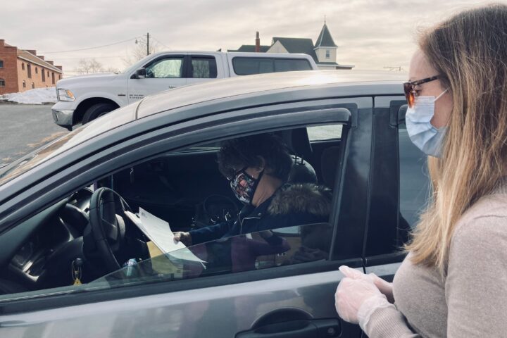 Employee greets a tax client at the client’s car to gather paperwork
